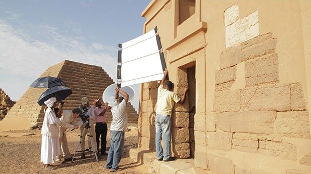 Filmteam mit Reflektoren und Sonnenschirmen an einem Tempel vor den Pyramiden von Meroe
