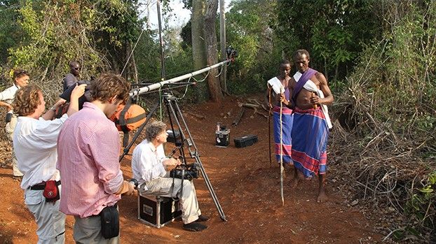 Filmteam mit Kamerakran im Wald, zwei Mijikenda-Männer in traditioneller Kleidung