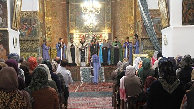 Gottesdienst in einer reich bemalten Kathedrale mit Geistlichen und Gemeinde