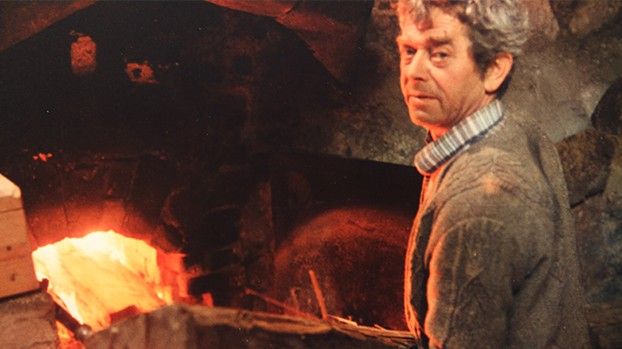 Mann vor dem glühenden Feuer eines Kalkofens