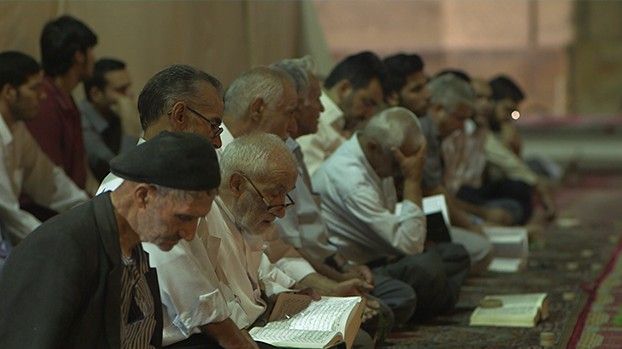 Männer lesen beim Gebet im Koran
